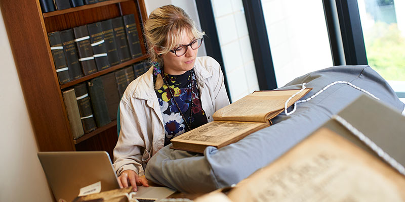 A researcher handles old texts