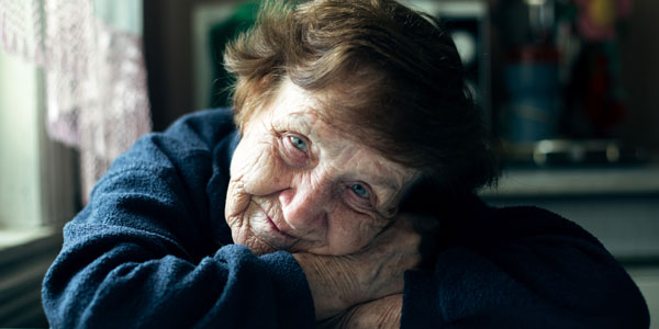 an older lady resting her head on folded arms